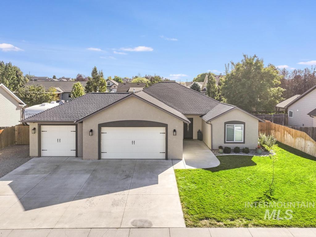 Ranch-style house featuring stucco siding, an attached garage, and driveway