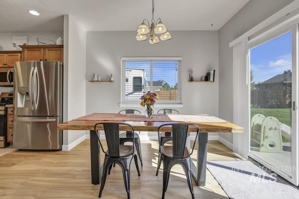 Dining area featuring light wood-type flooring and a chandelier