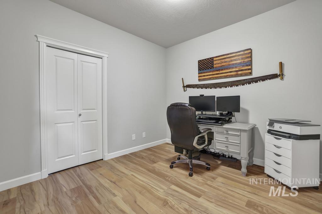 Office area with baseboards and light wood-type flooring