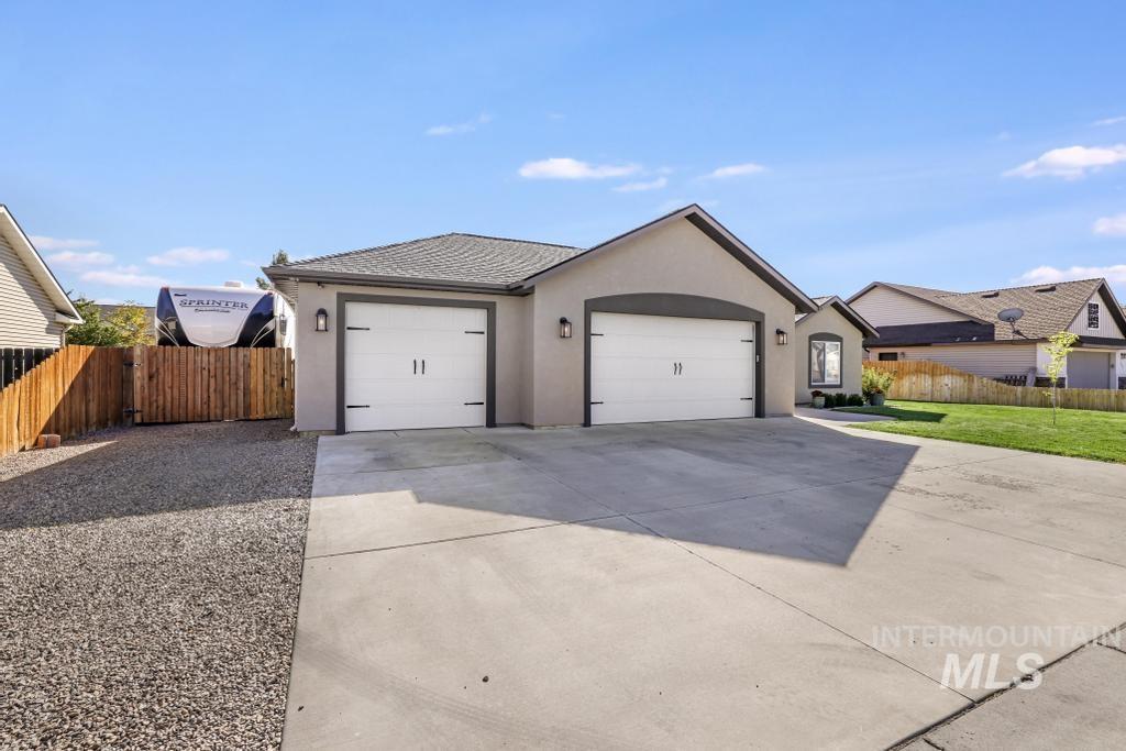 Single story home featuring stucco siding, concrete driveway, and a garage