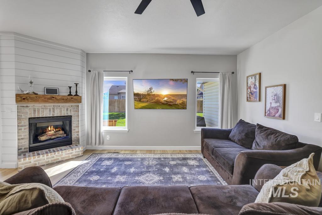 Living room featuring a fireplace and a ceiling fan