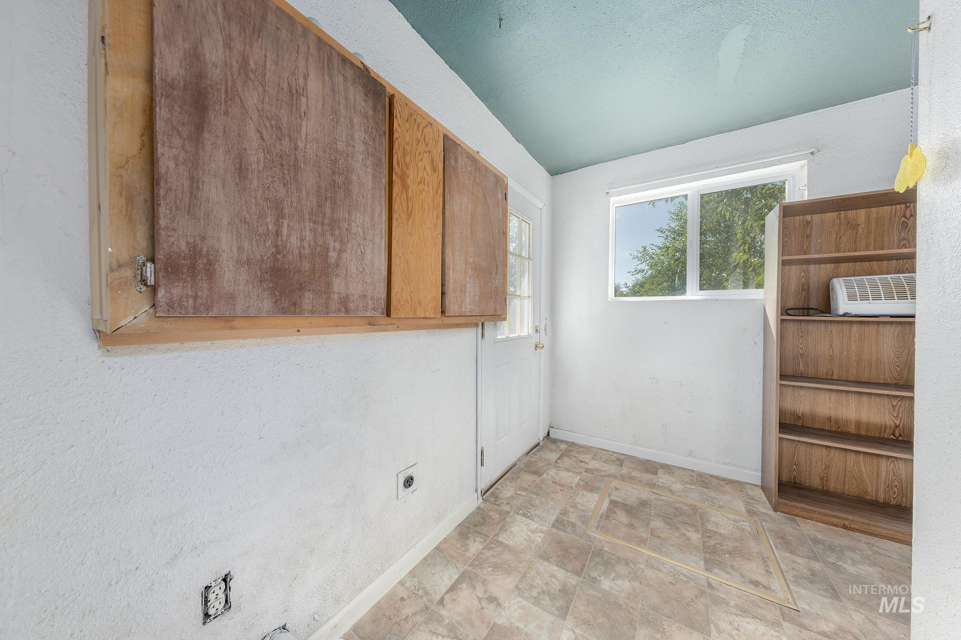 Spare room featuring baseboards and stone finish flooring