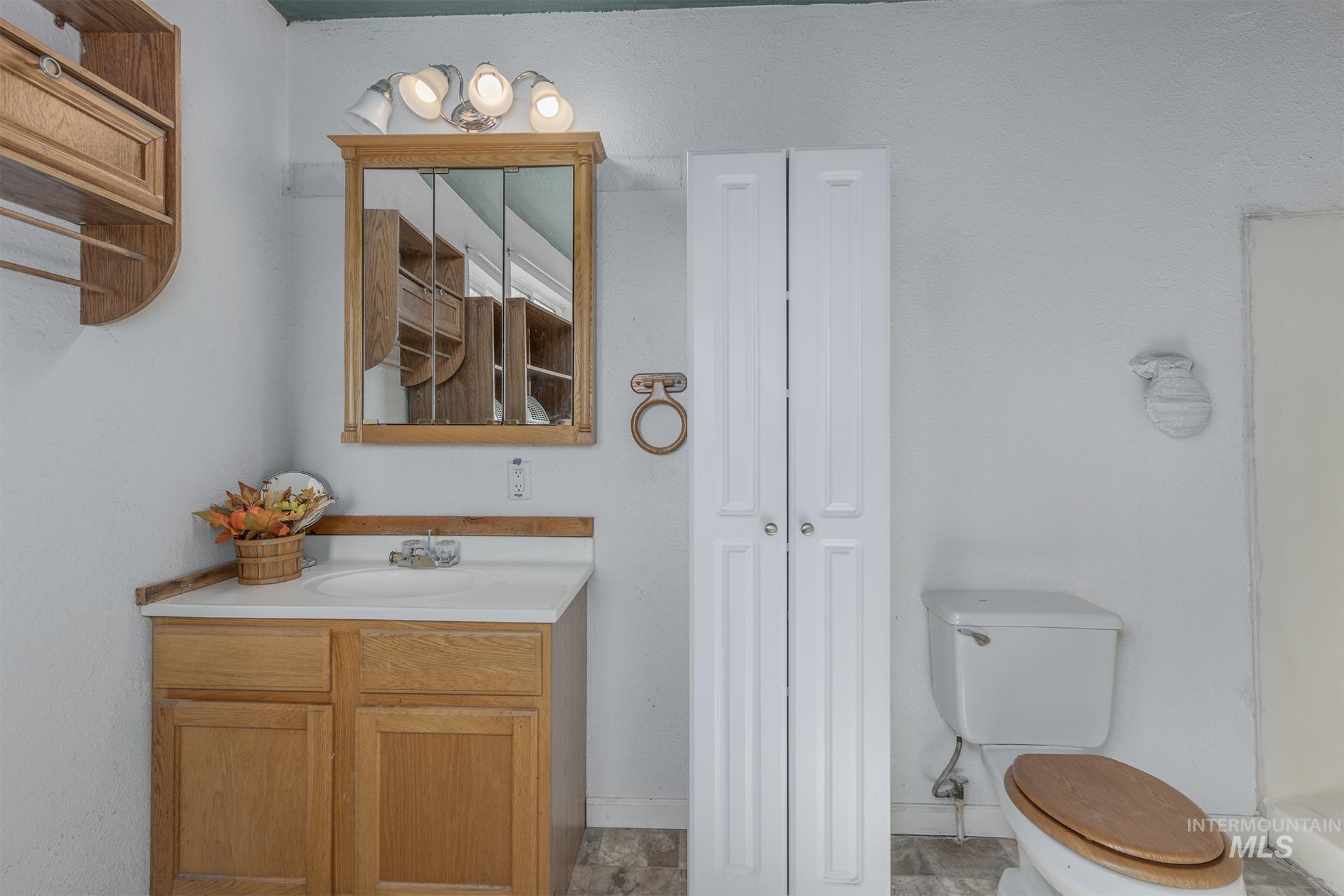 Bathroom with vanity and a closet