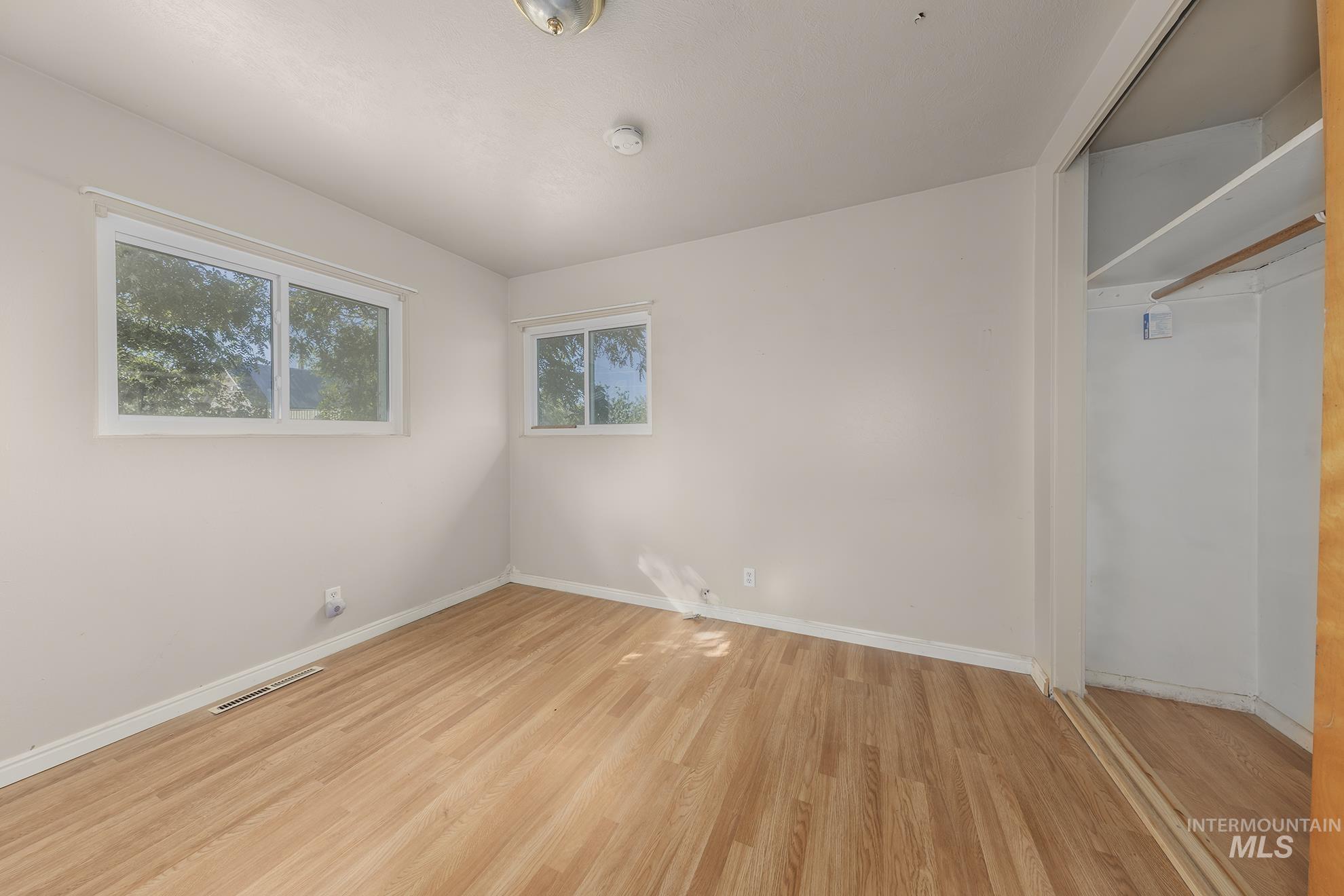 Unfurnished bedroom featuring light wood-style flooring and a closet