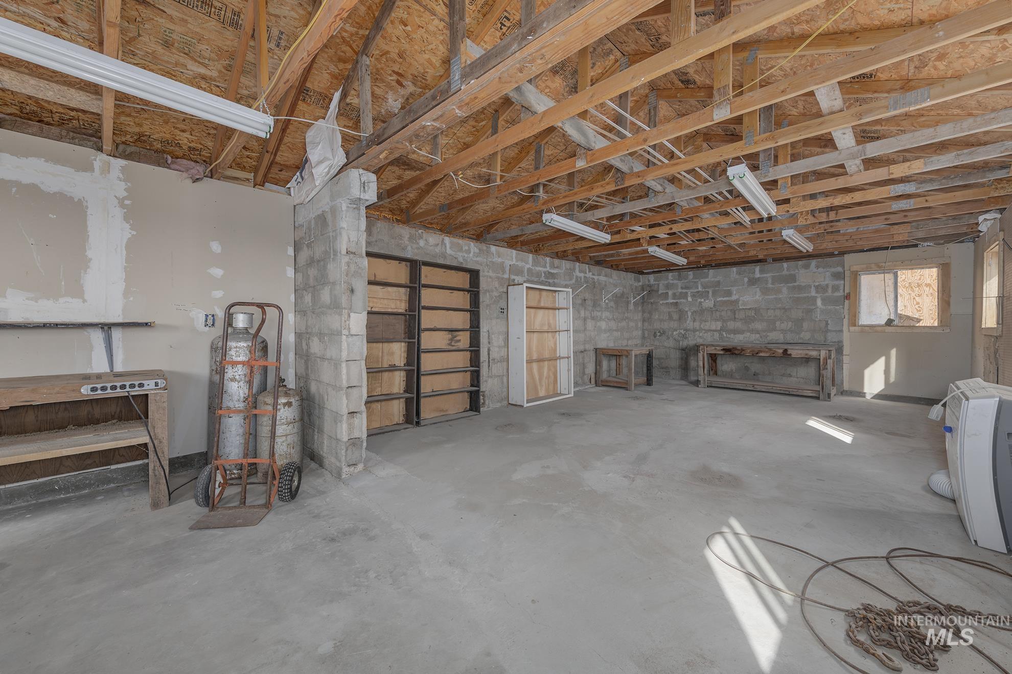 Misc room with unfinished concrete flooring and a garage