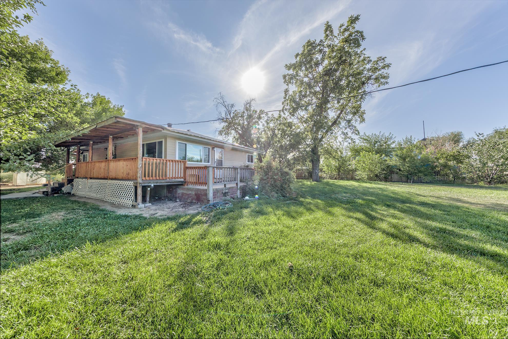 View of green lawn featuring a wooden deck