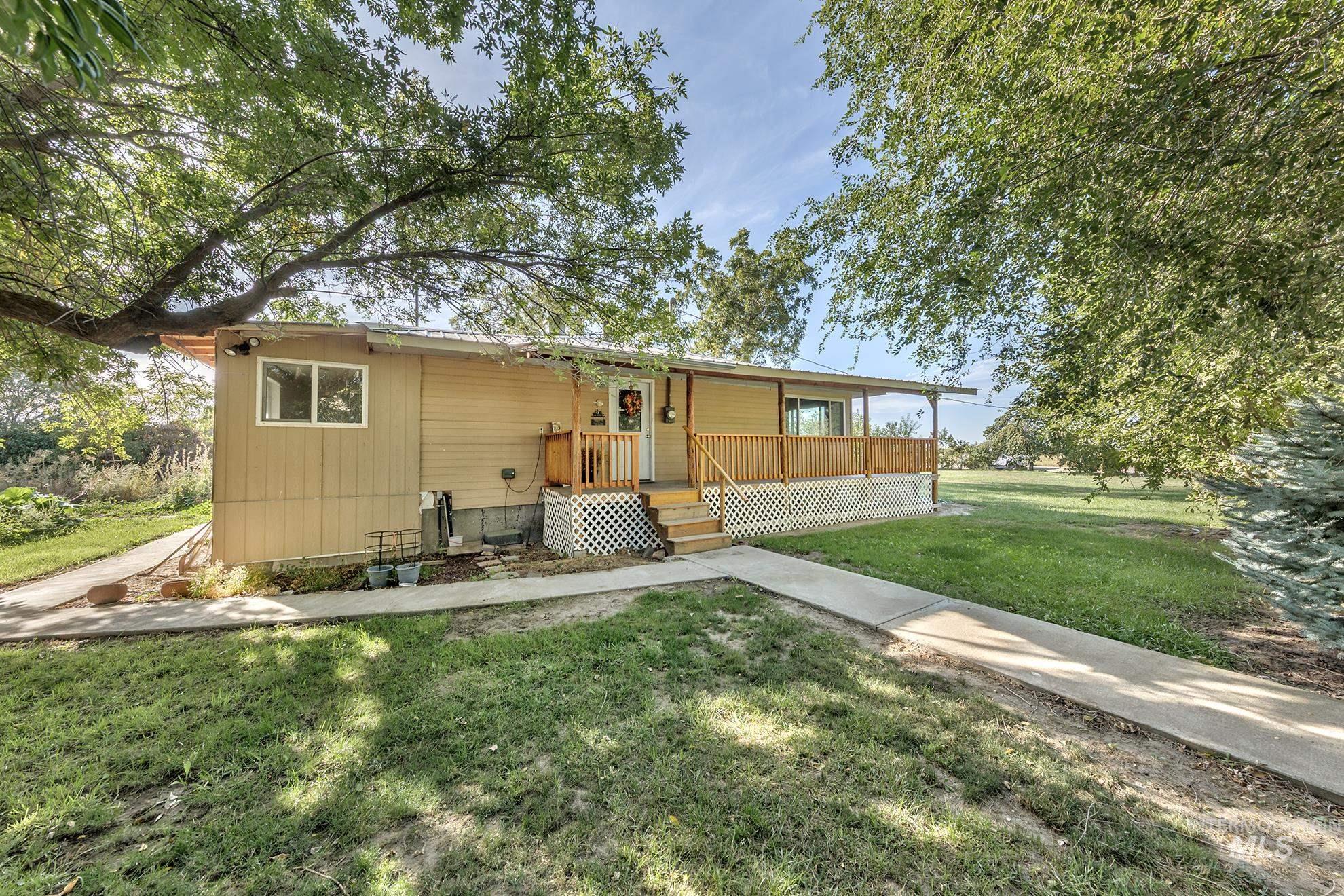Rear view of property featuring a yard and covered porch