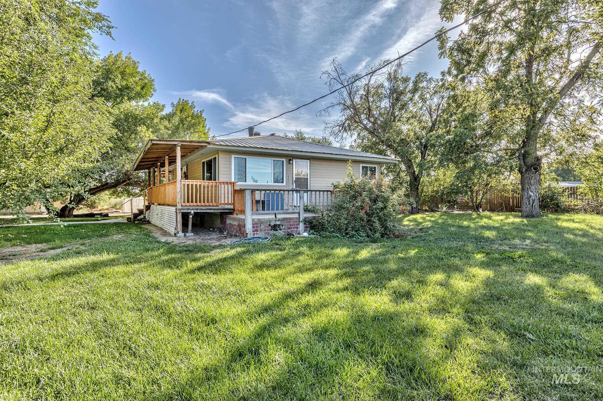 Back of property featuring a yard and a metal roof