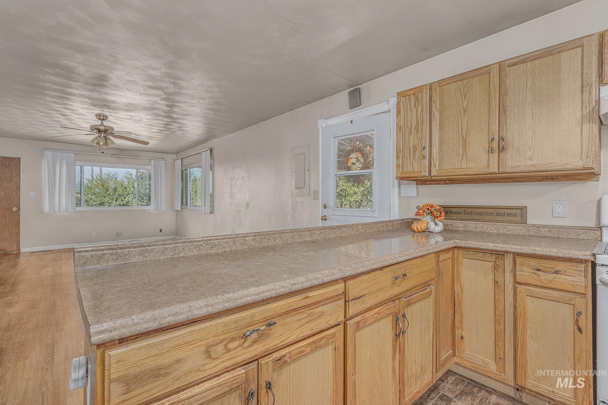 Kitchen with light countertops, light brown cabinets, a peninsula, and open floor plan
