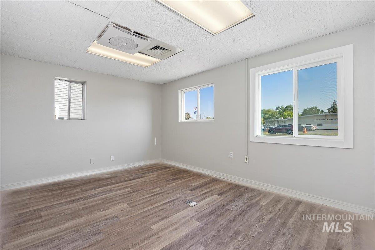 Empty room with wood finished floors and a drop ceiling