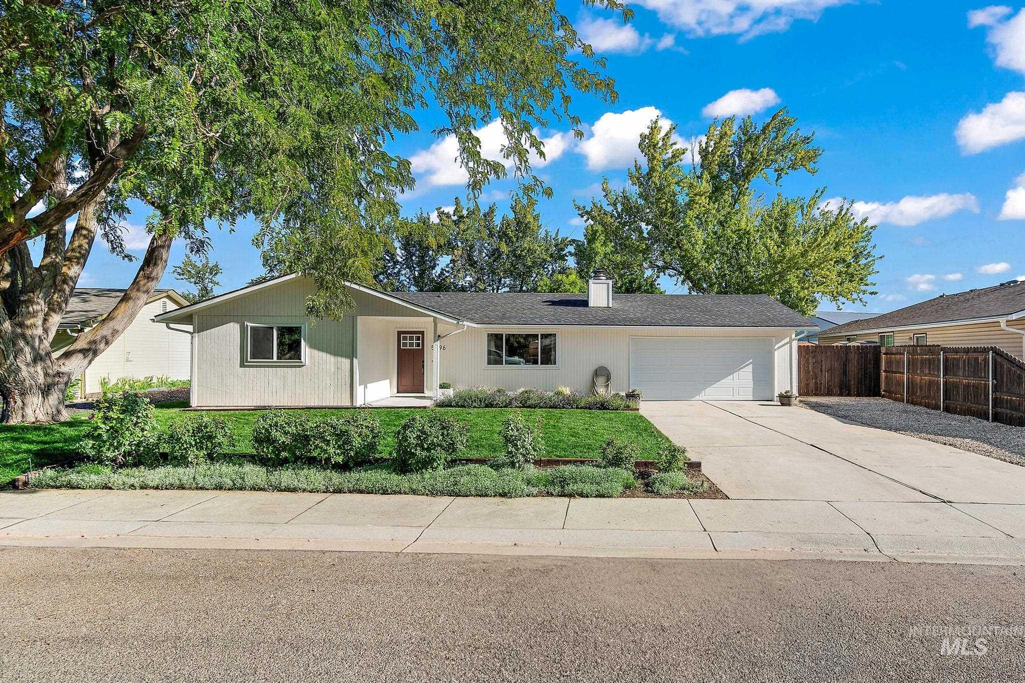 Single story home featuring driveway, an attached garage, and a chimney