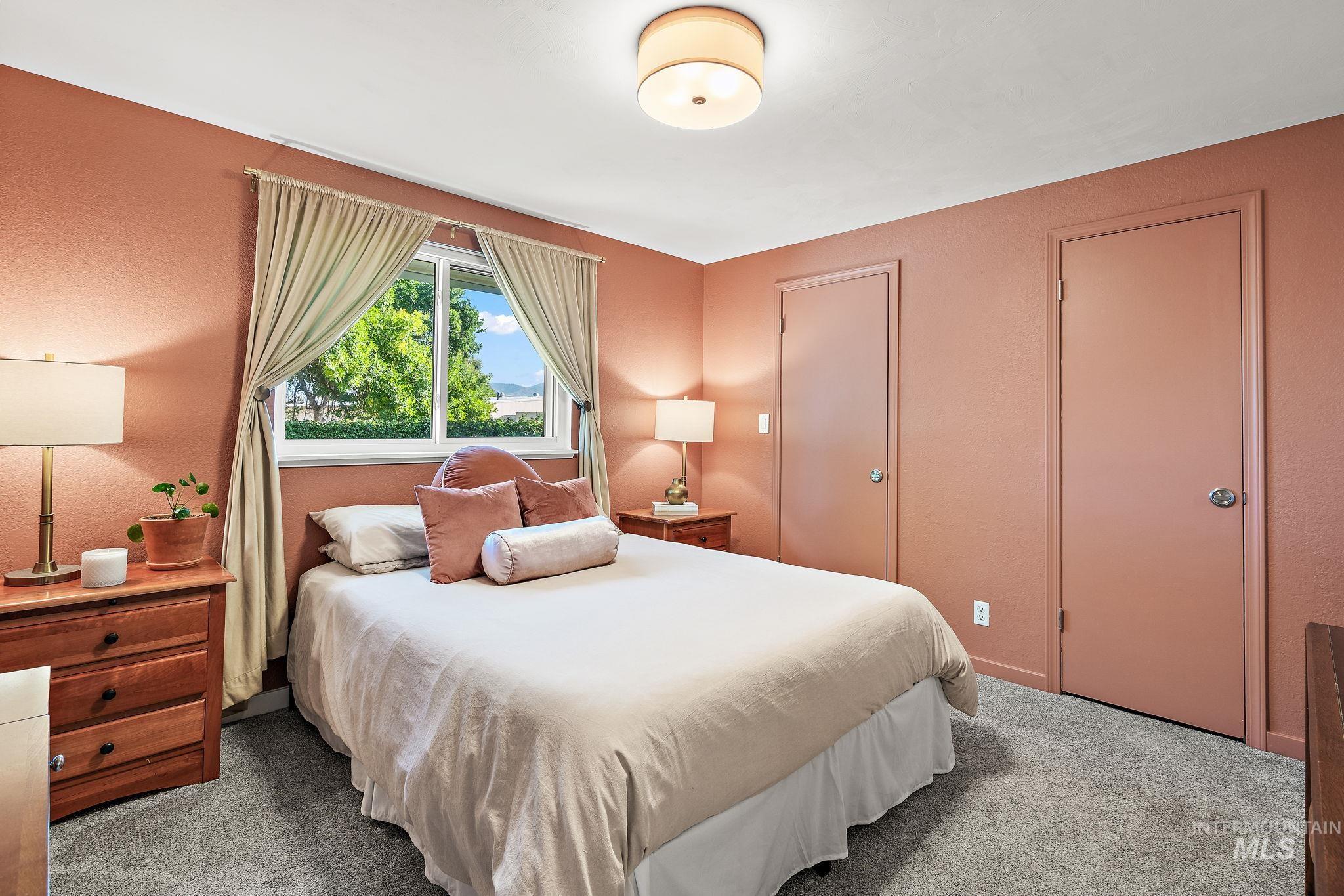 Bedroom with carpet, a textured wall, and a closet