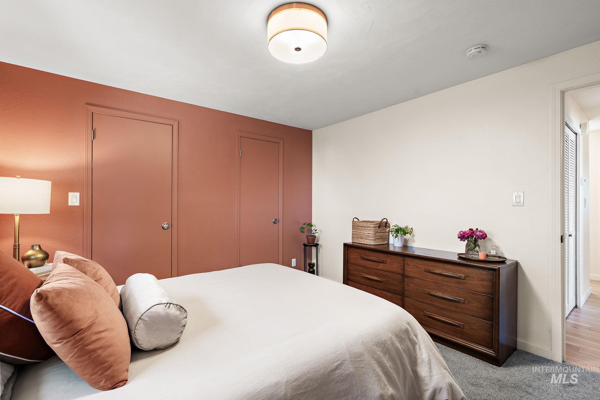 Bedroom with light colored carpet and a closet