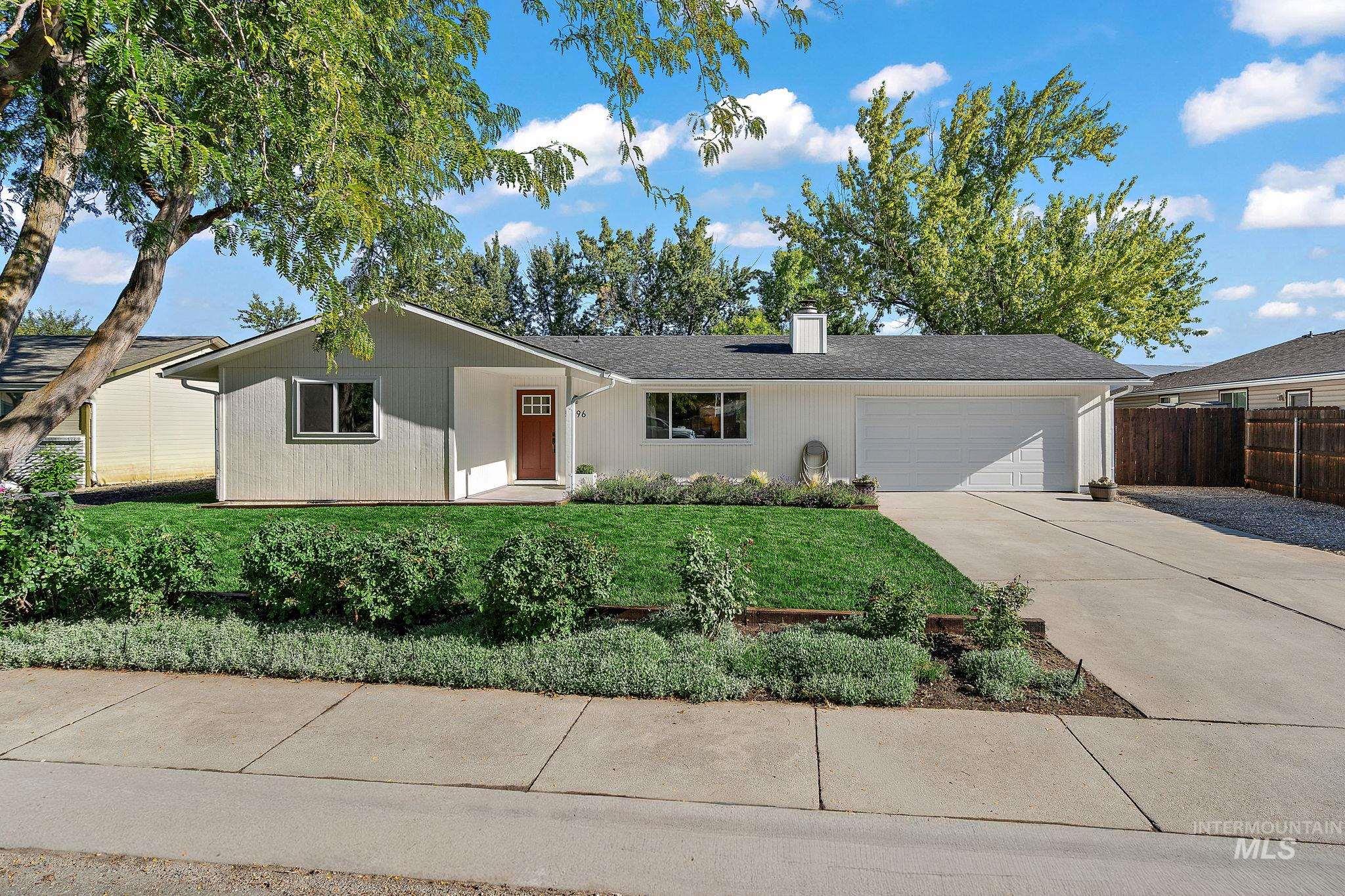 Ranch-style house with driveway, a chimney, and an attached garage