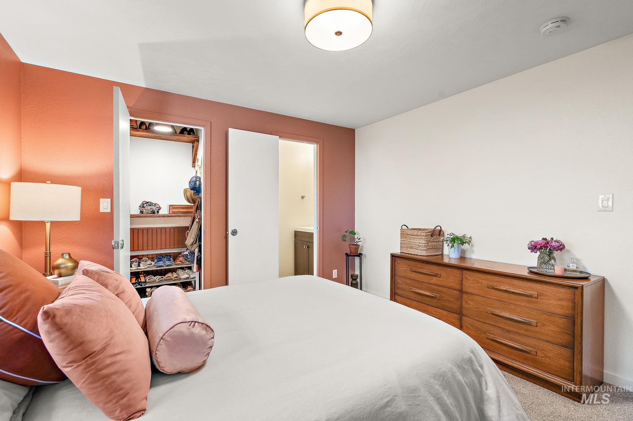 Bedroom featuring light carpet and connected bathroom