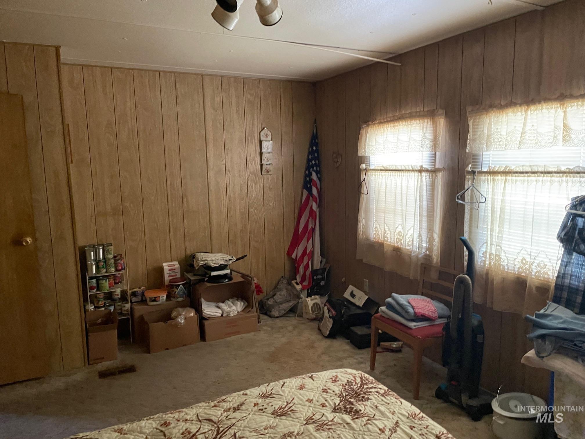 Bedroom with wooden walls and carpet flooring