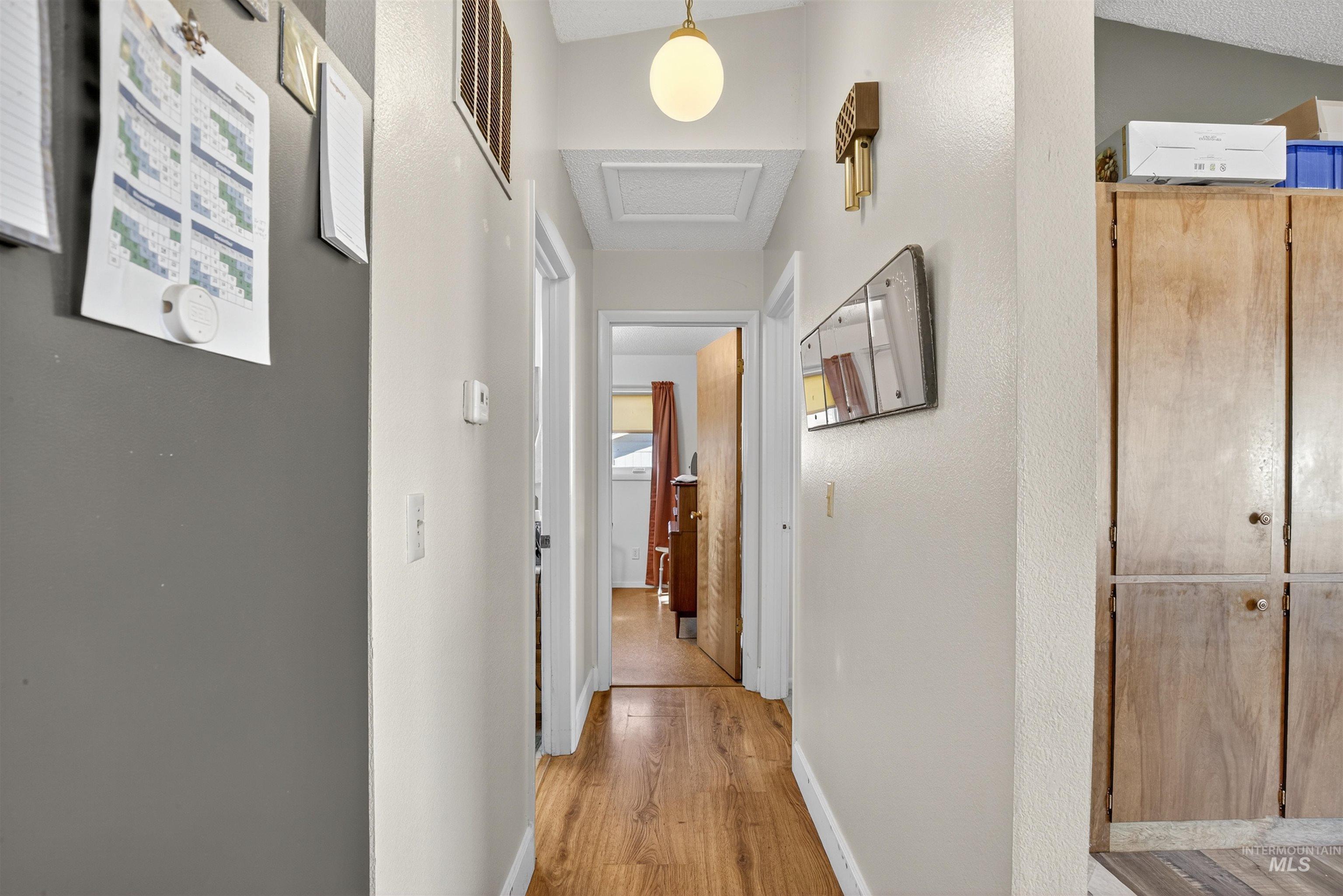 Hall featuring light wood-type flooring and attic access