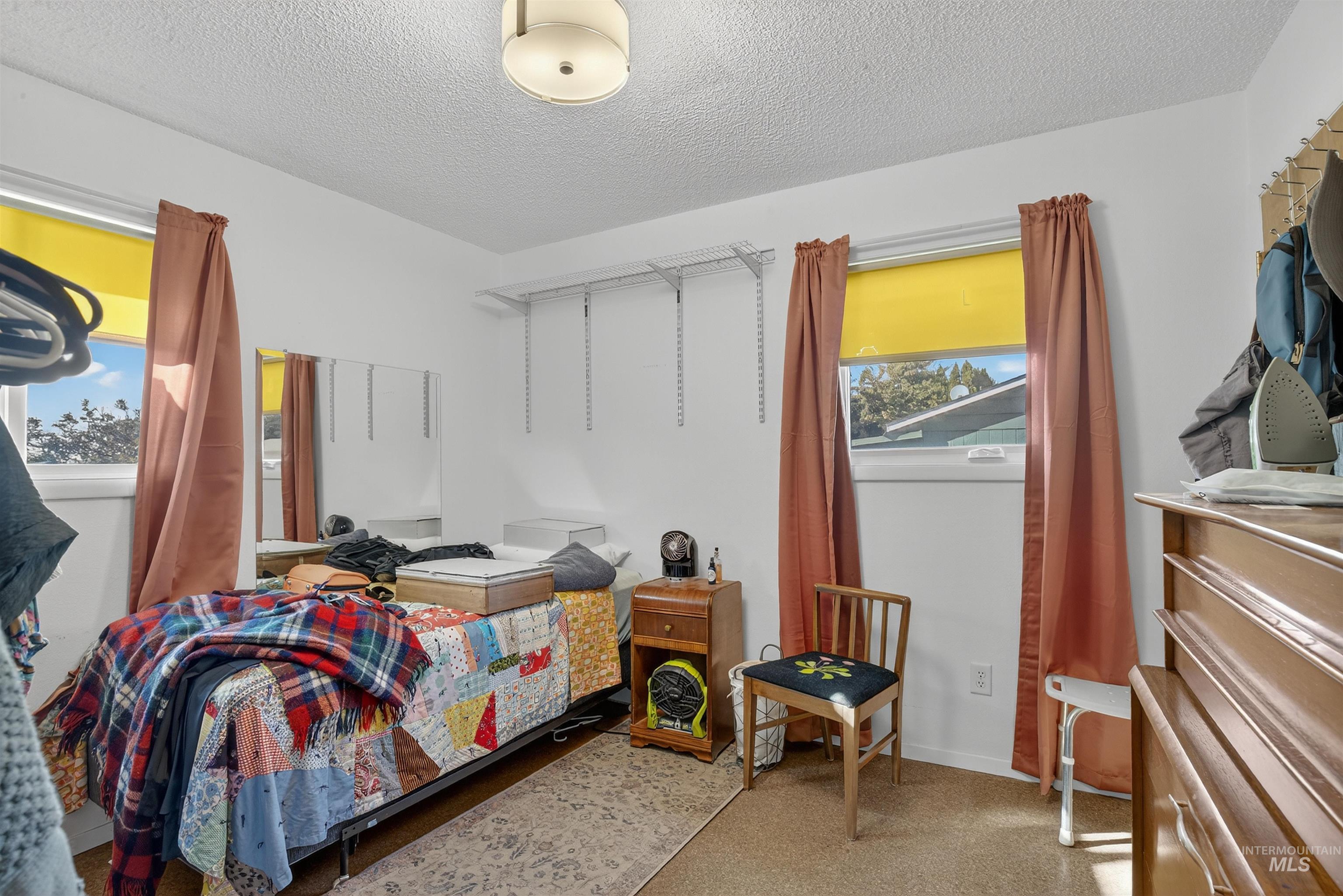 Bedroom featuring a textured ceiling and baseboards