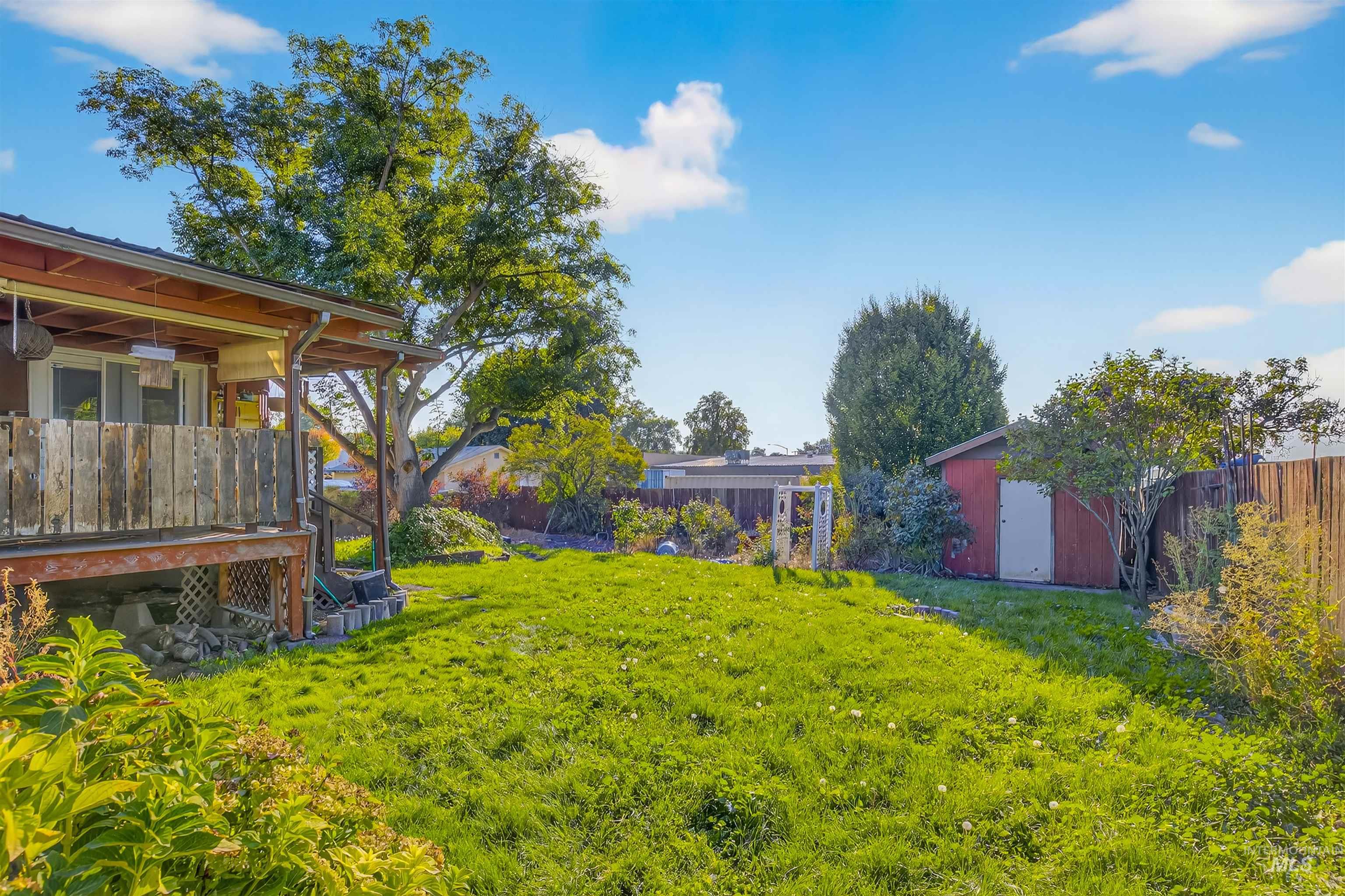 Fenced backyard with a shed and a deck