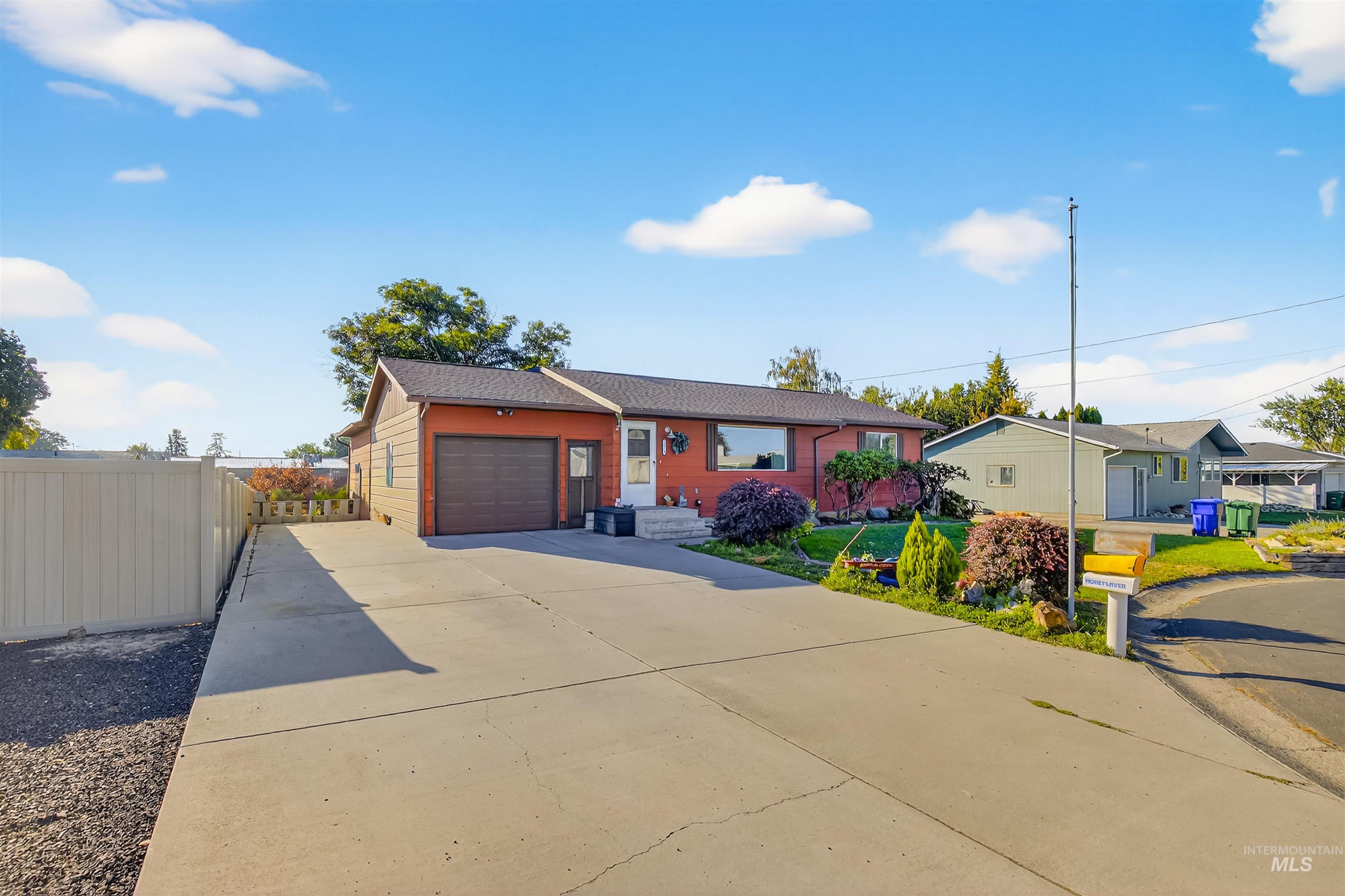 Single story home featuring concrete driveway and a garage