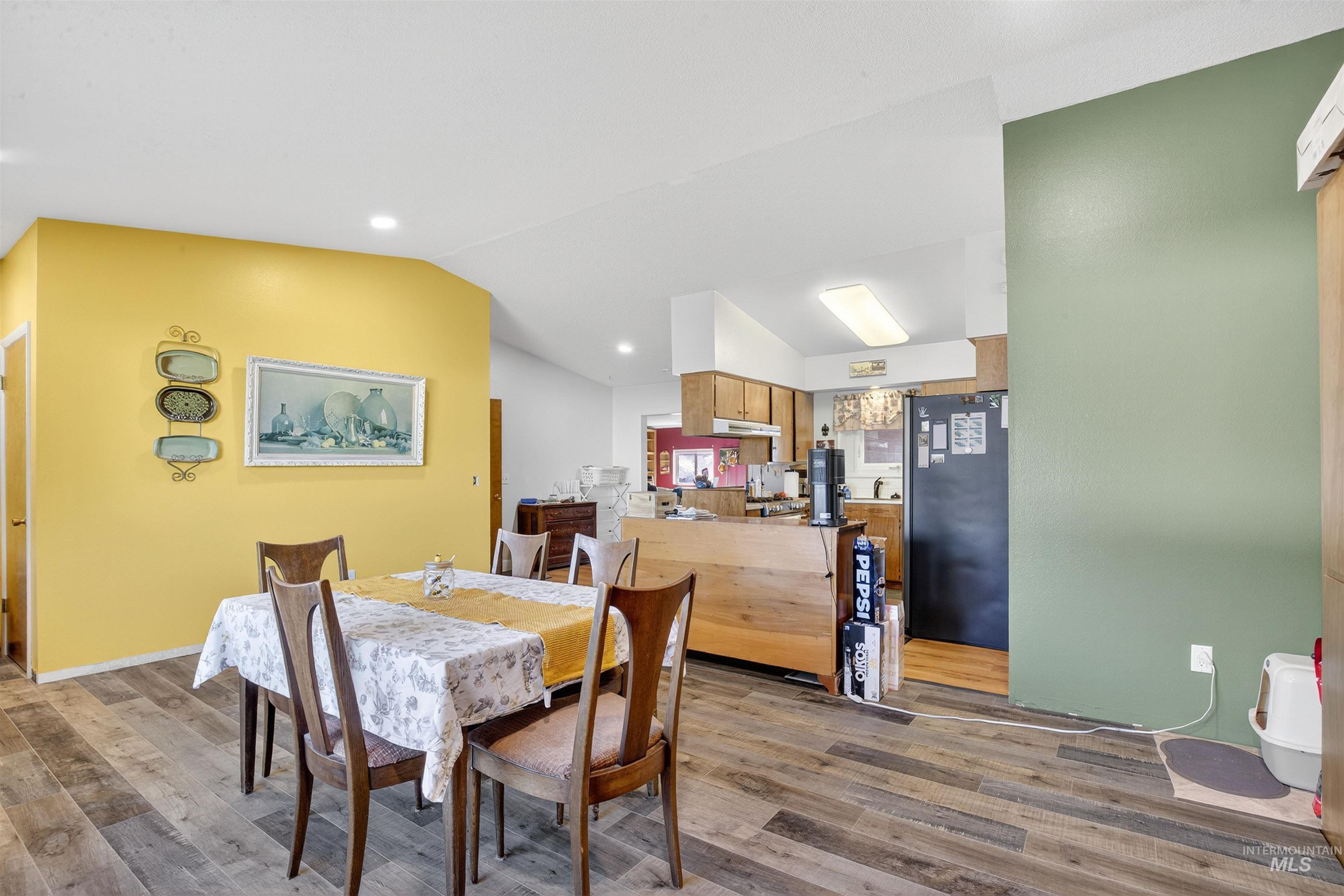 Dining room featuring wood finished floors, lofted ceiling, and recessed lighting
