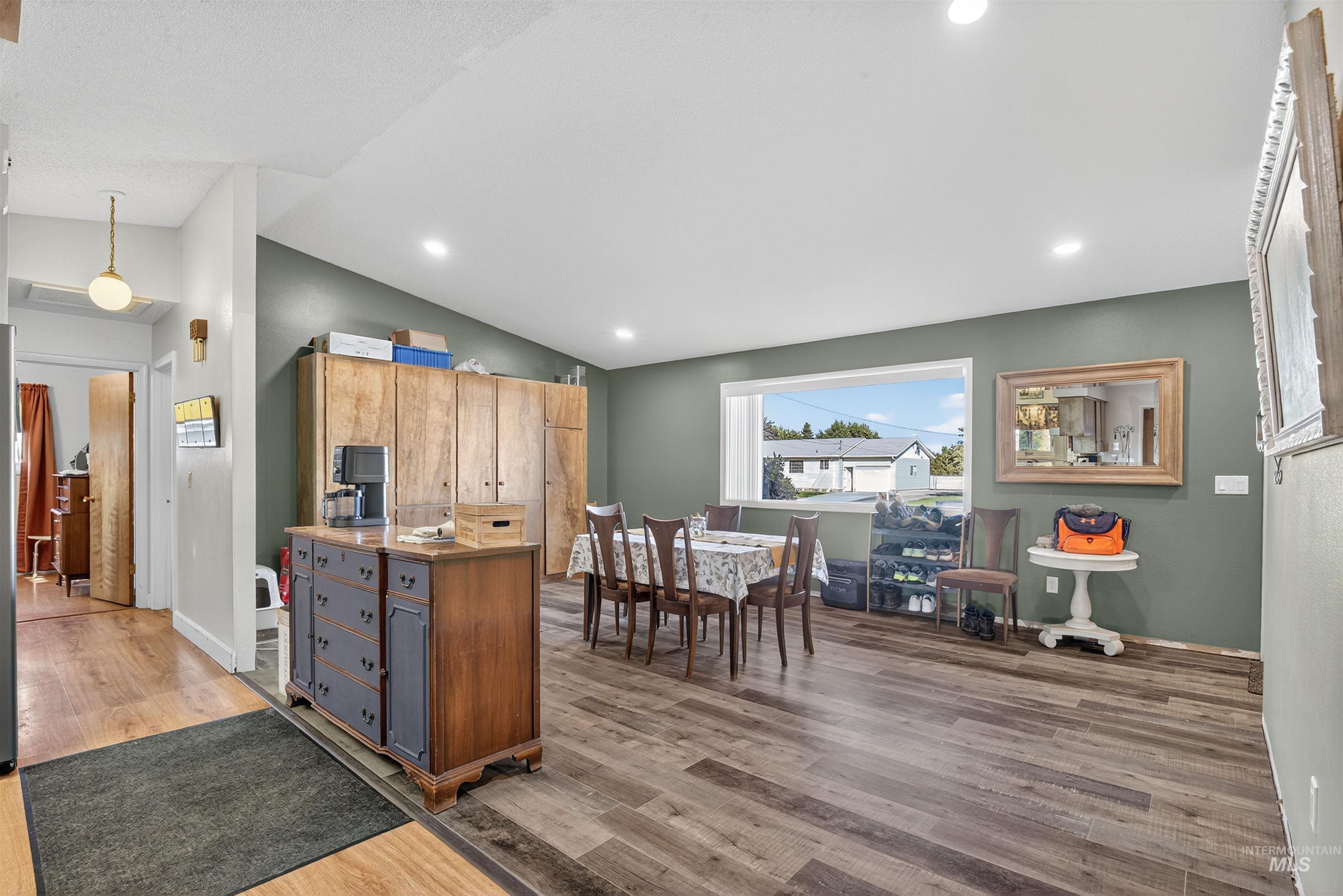 Kitchen with lofted ceiling, light wood-style floors, recessed lighting, and pendant lighting