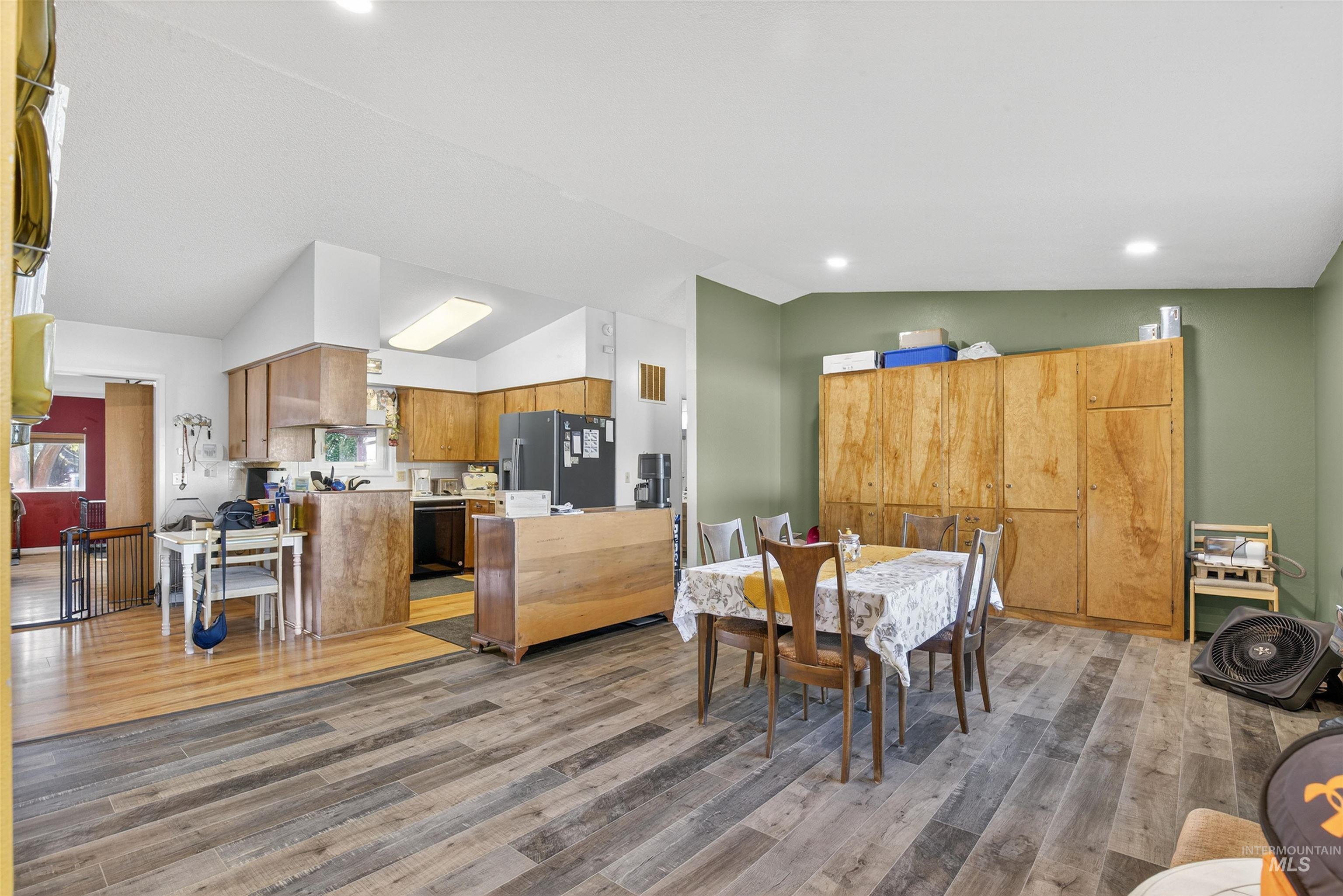Dining room featuring lofted ceiling, light wood-style flooring, and recessed lighting