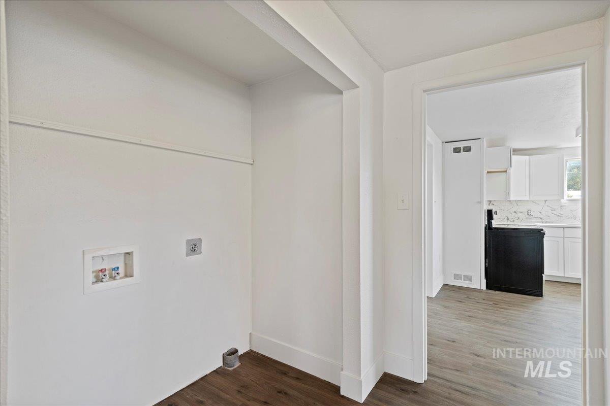 Washroom featuring dark wood finished floors, hookup for a washing machine, and electric dryer hookup