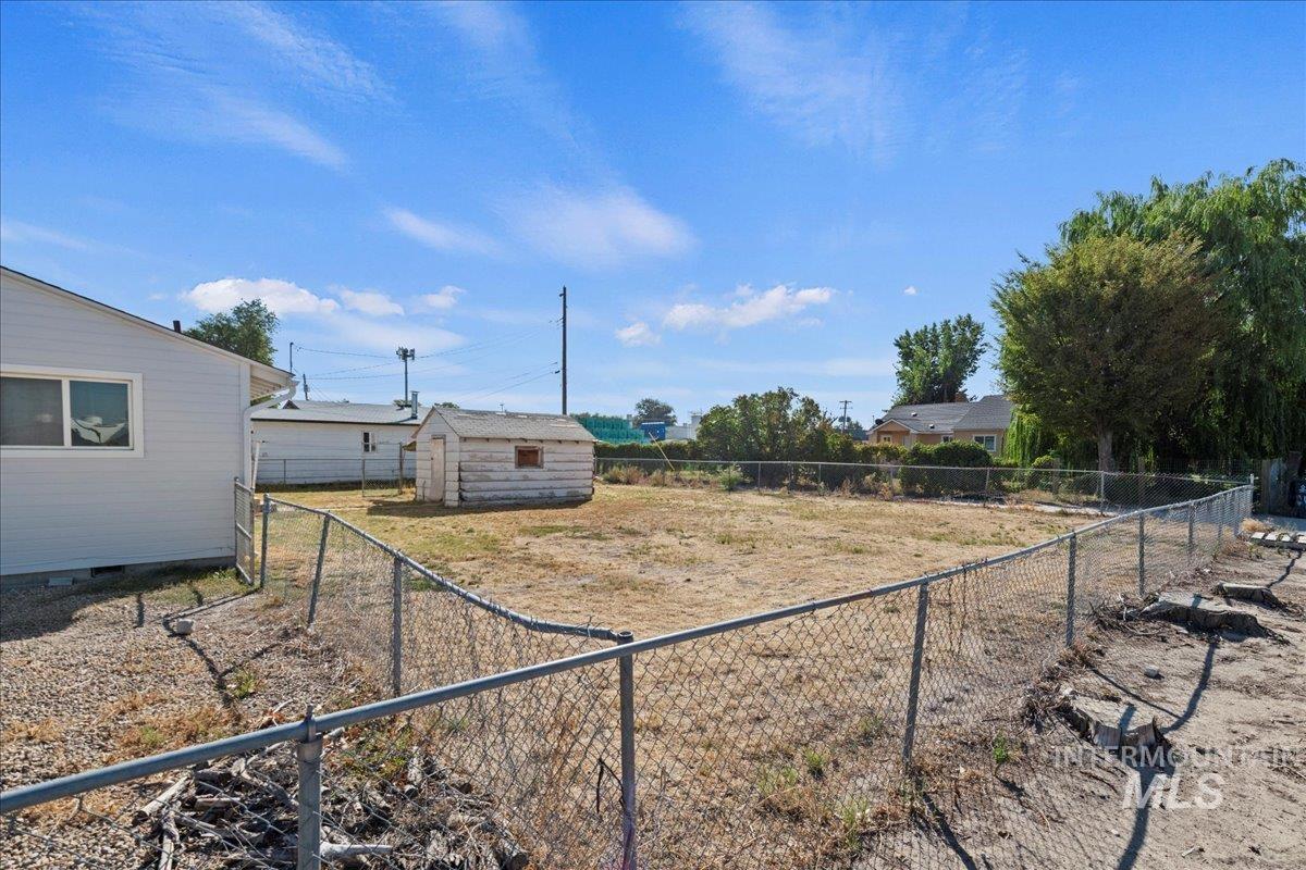 Fenced backyard with an outdoor structure