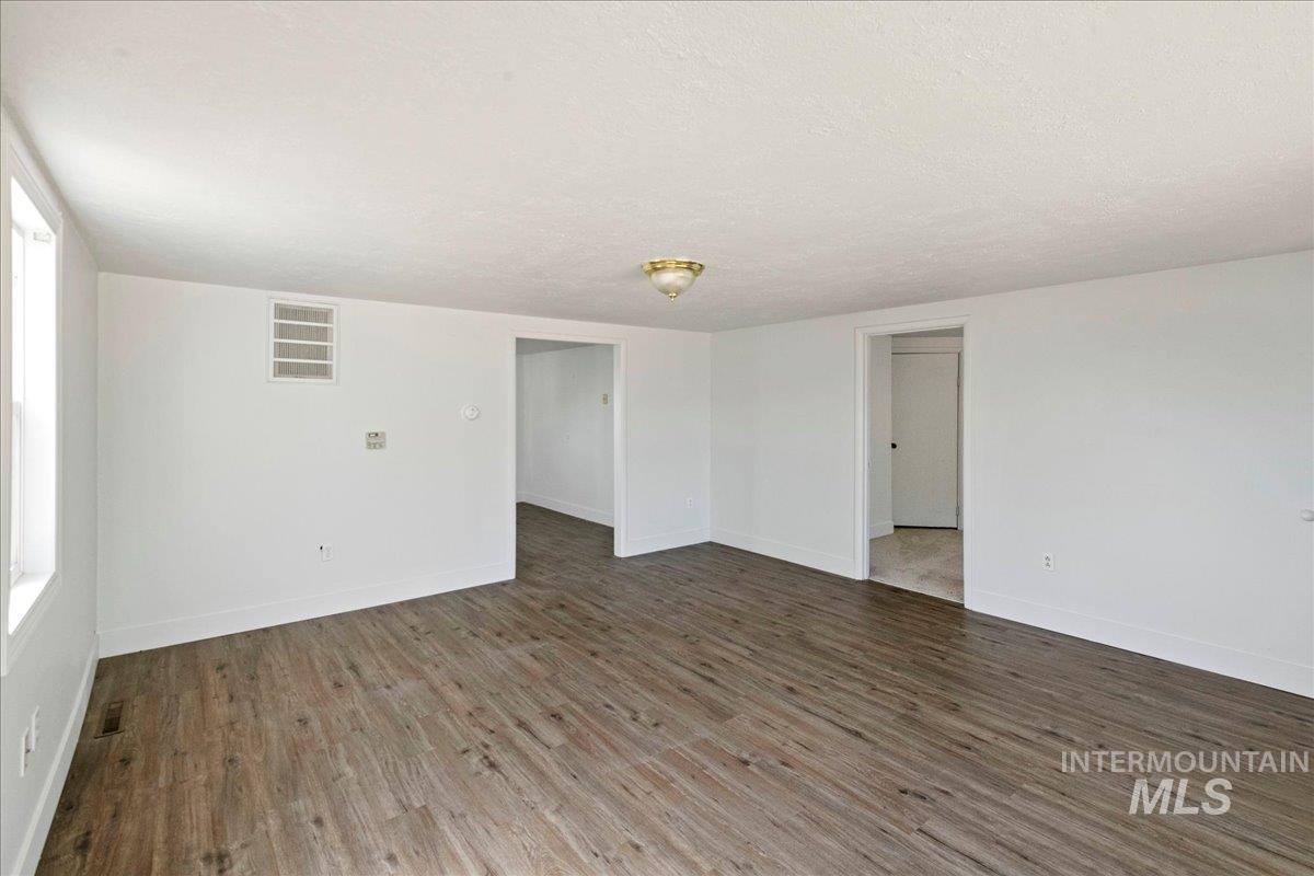 Unfurnished room featuring wood finished floors and a textured ceiling