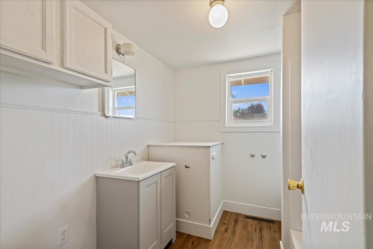Laundry room featuring wood finished floors and a sink