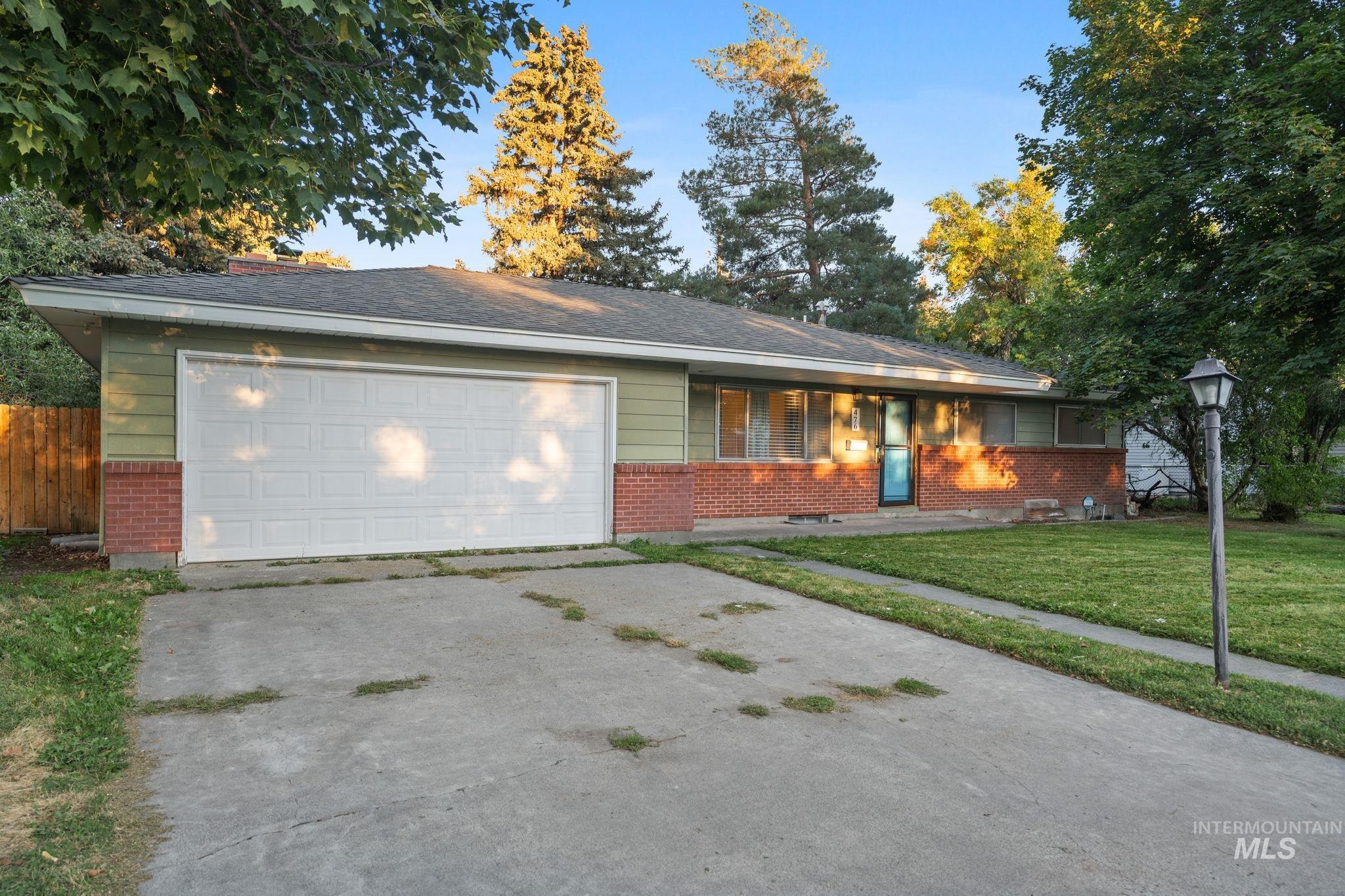Ranch-style house featuring brick siding, concrete driveway, and an attached garage