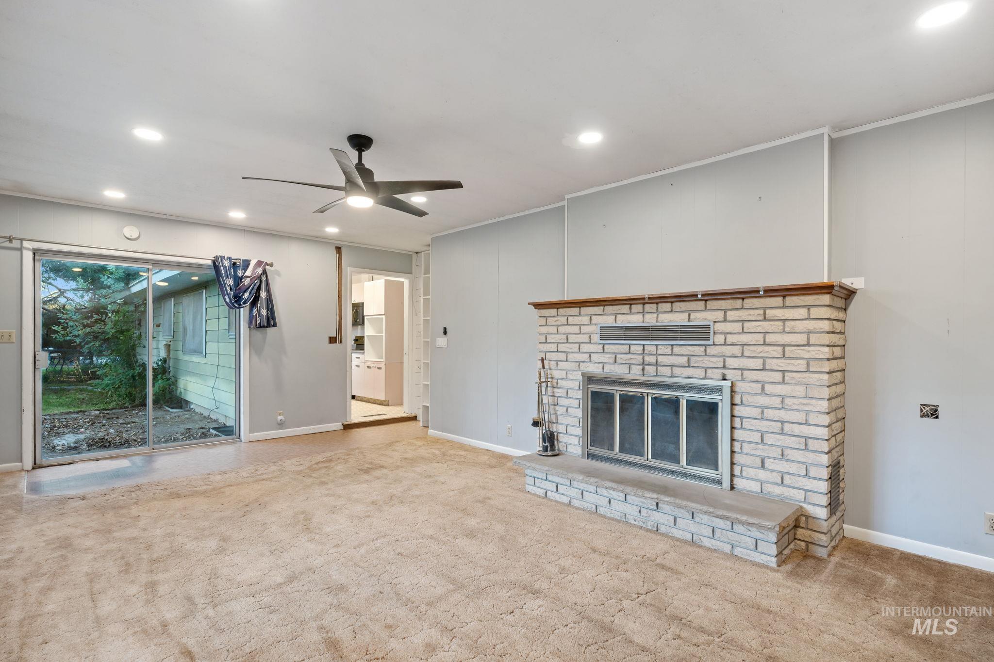 Unfurnished living room featuring carpet floors, a fireplace, recessed lighting, and ceiling fan