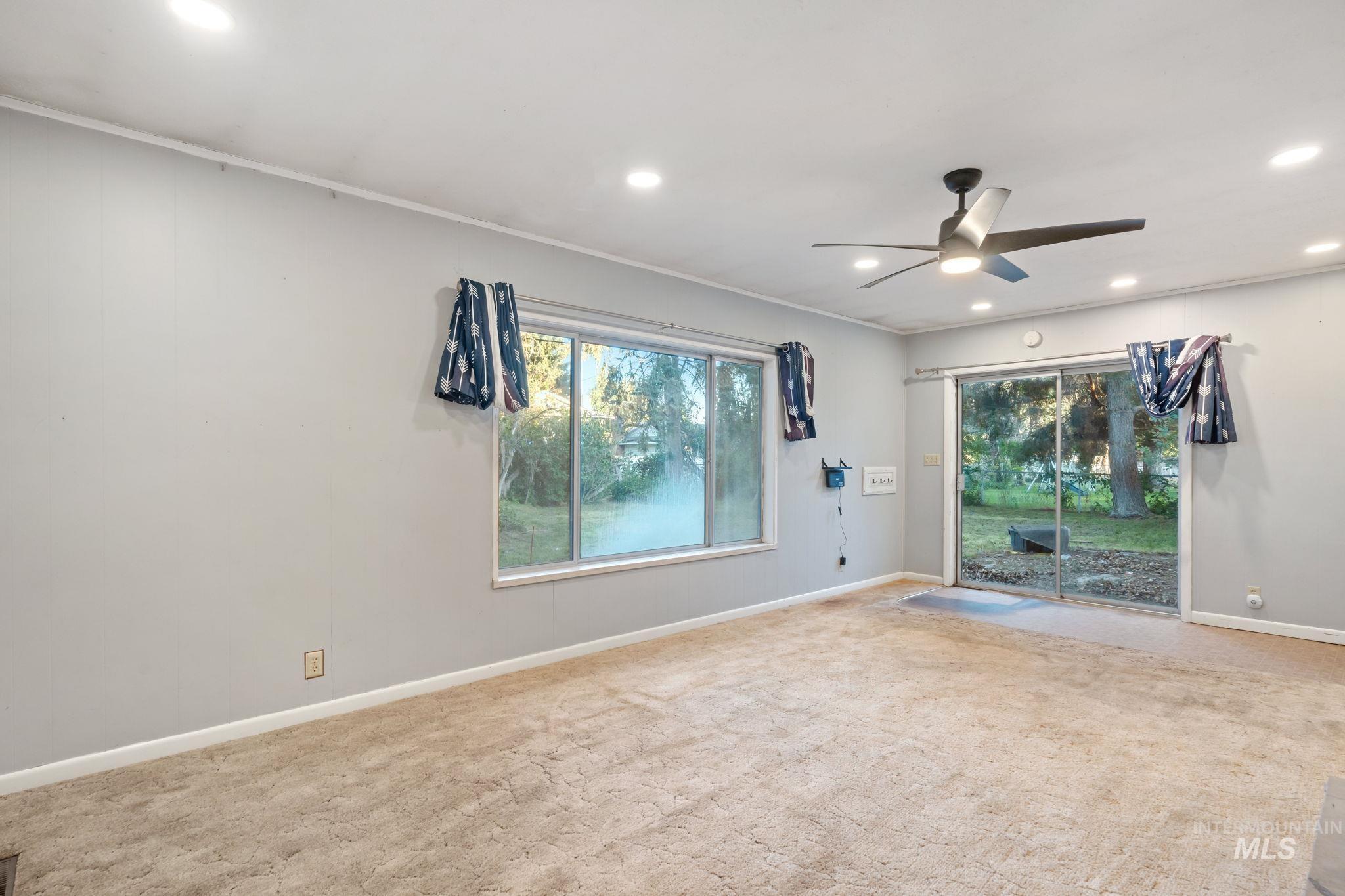 Carpeted empty room featuring healthy amount of natural light, ceiling fan, and recessed lighting