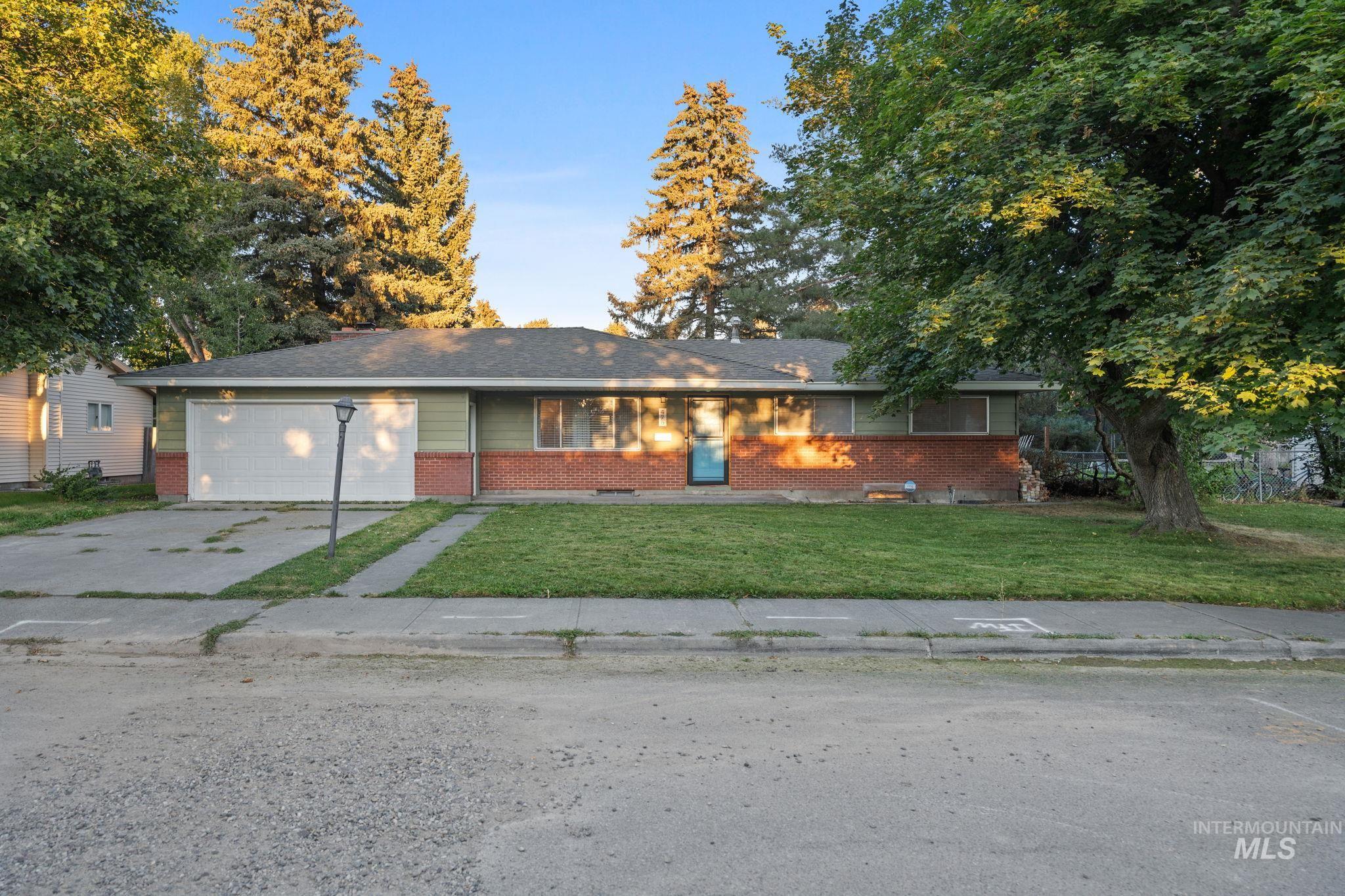 Single story home with brick siding, a front lawn, and concrete driveway