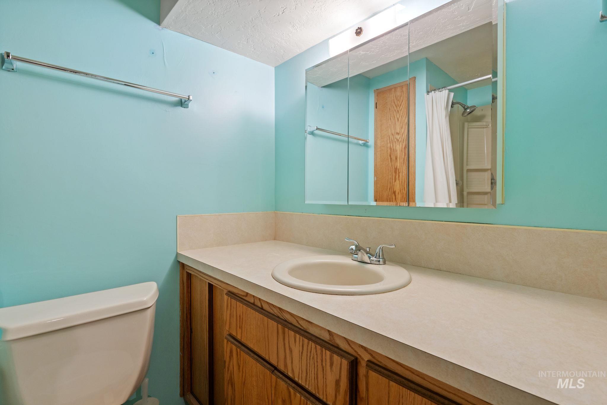 Full bath with vanity, a textured ceiling, and a shower with curtain