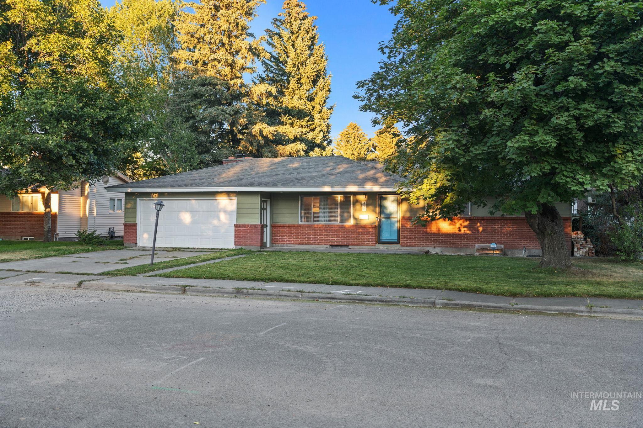 Ranch-style home with driveway, a front yard, brick siding, and an attached garage