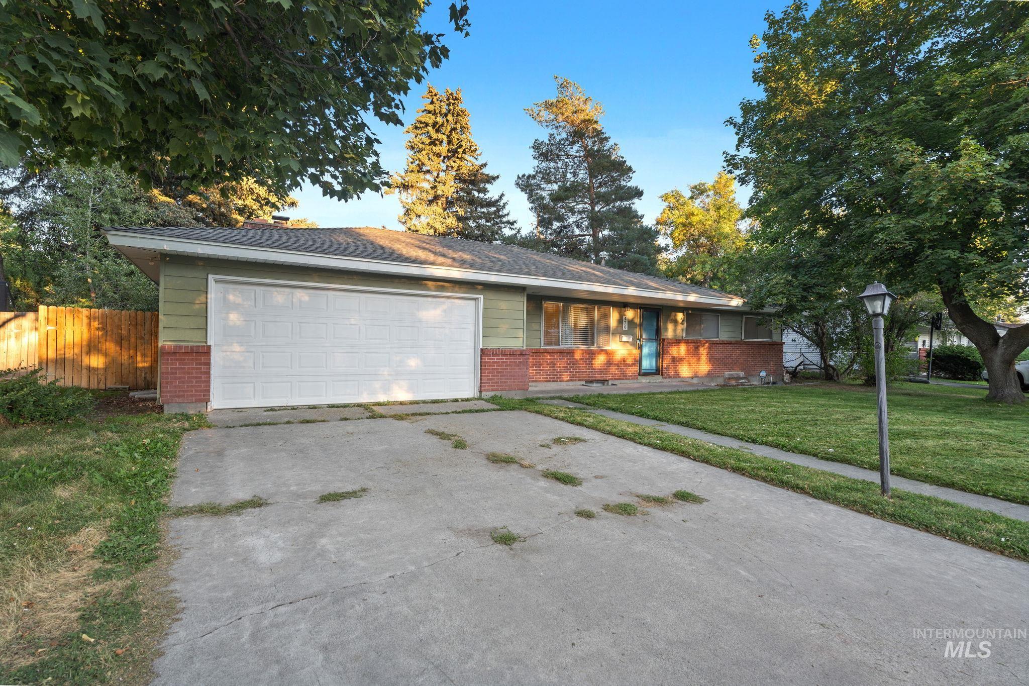 Single story home with brick siding, driveway, and an attached garage
