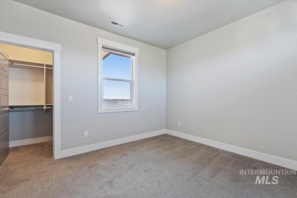 Unfurnished bedroom featuring a spacious closet and light carpet