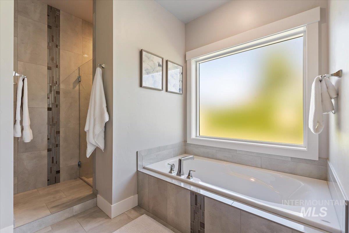 Full bath with a garden tub, a shower stall, and light tile patterned floors