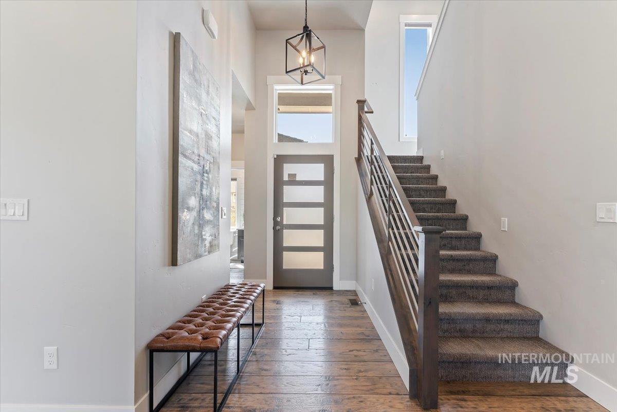 Entryway featuring dark wood finished floors, a high ceiling, and stairs