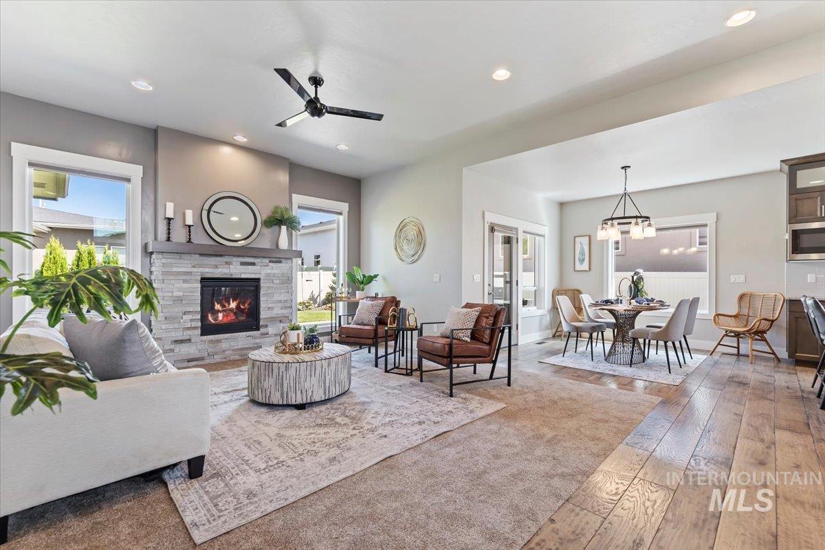 Living area with hardwood / wood-style flooring, ceiling fan, recessed lighting, a chandelier, and a fireplace