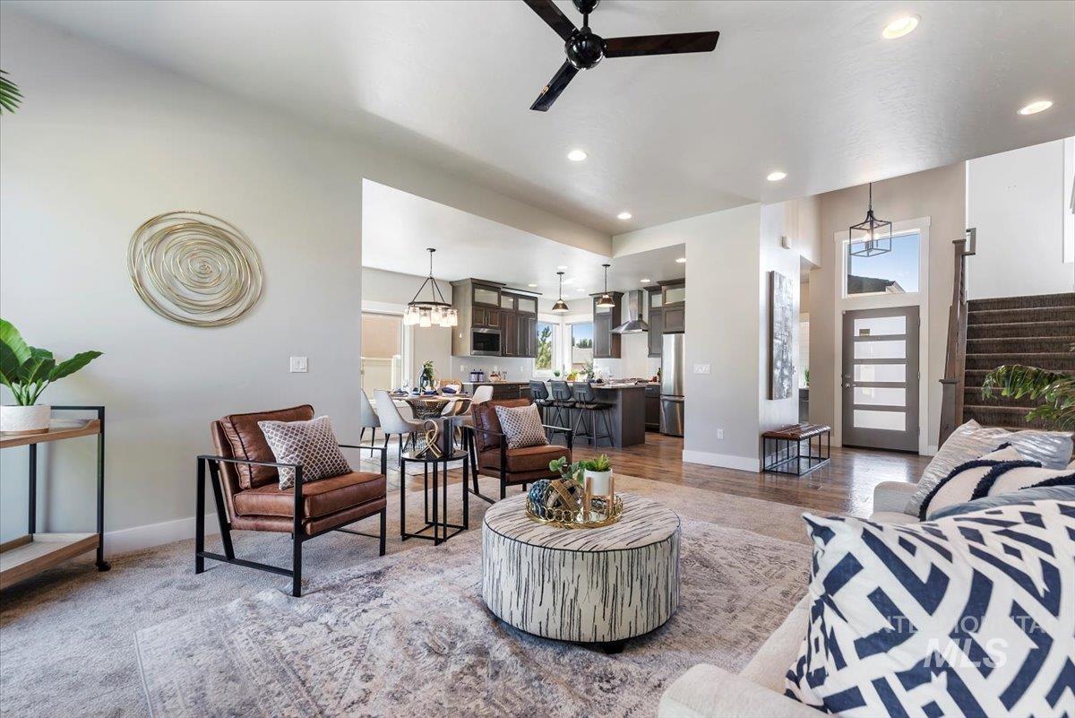 Living area with stairs, healthy amount of natural light, recessed lighting, a ceiling fan, and a chandelier