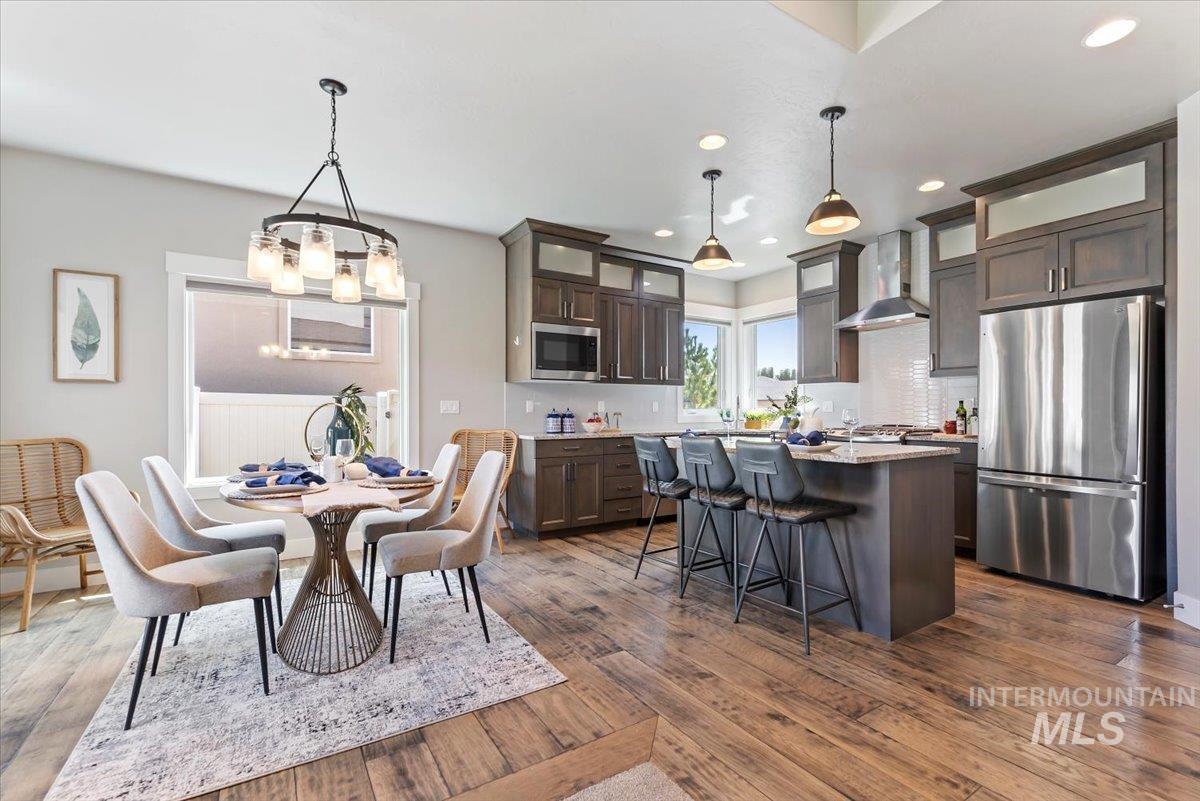 Dining area featuring dark wood-style flooring, recessed lighting, and a chandelier