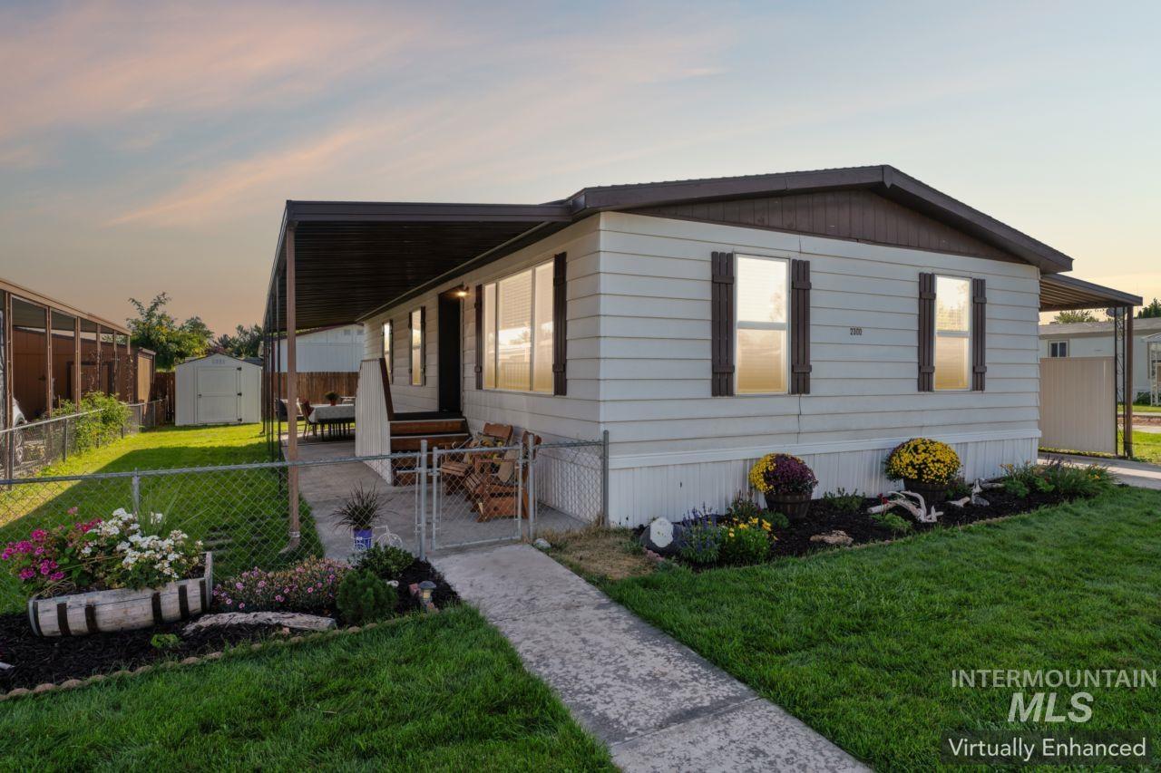 View of front of home with a gate, a storage unit, and a porch