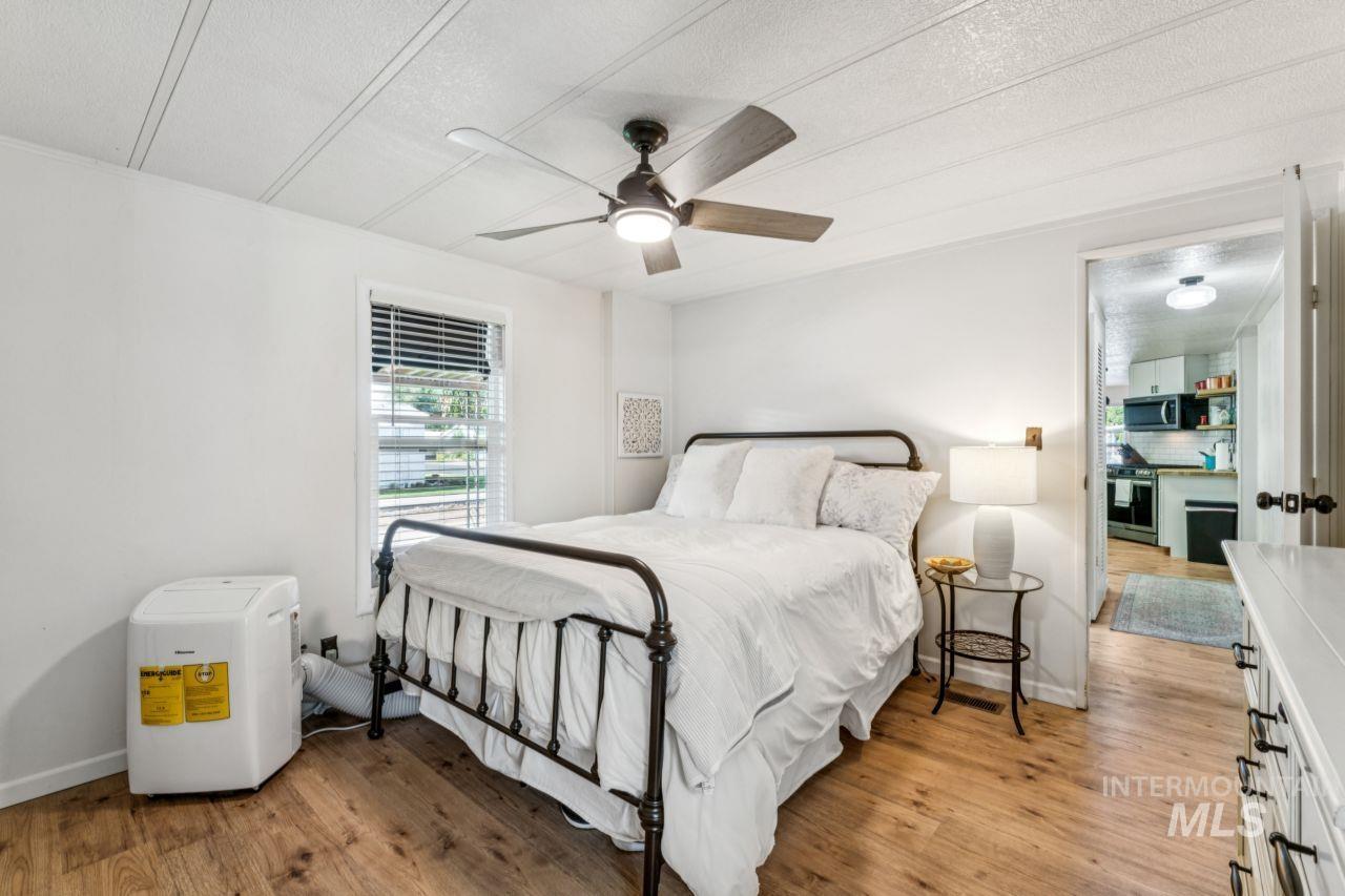 Bedroom featuring light wood-style flooring, a textured ceiling, and ceiling fan
