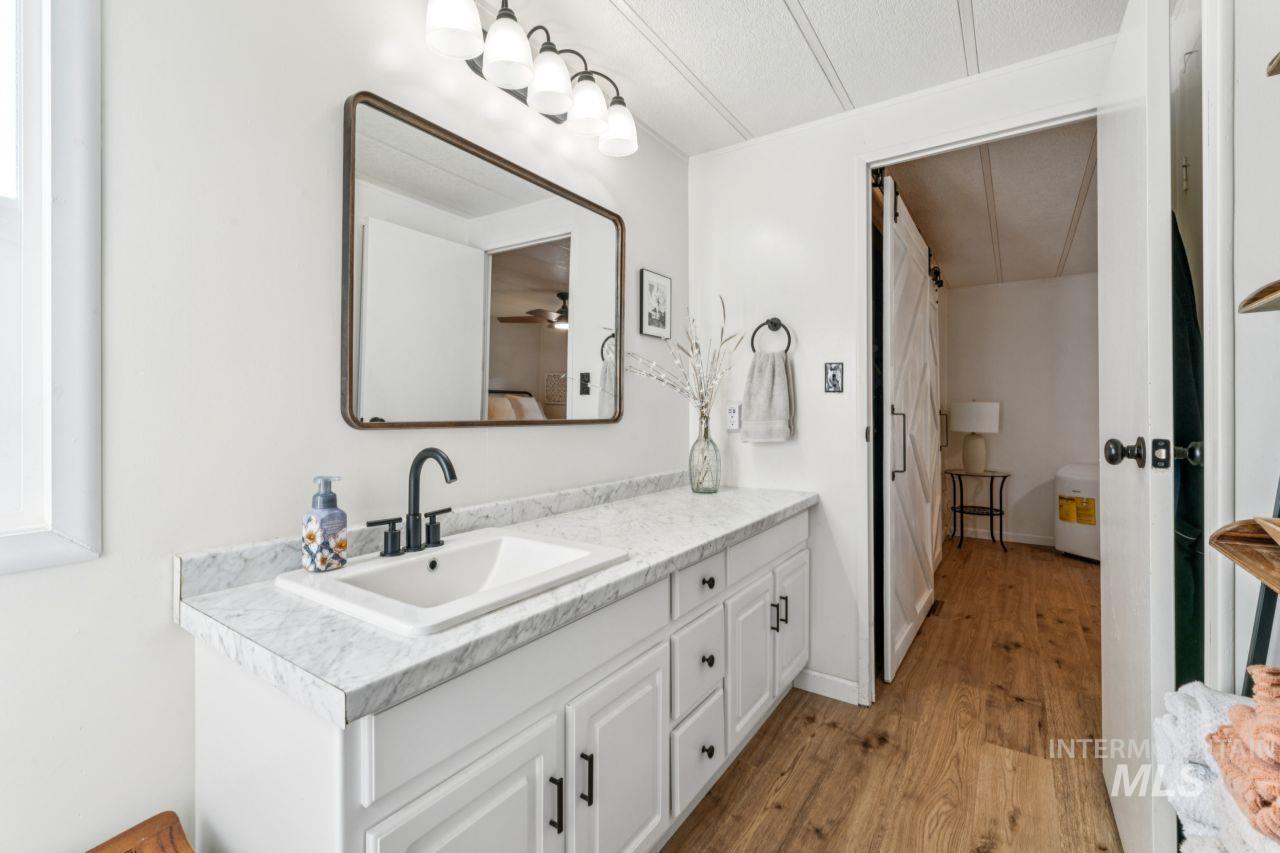 Bathroom featuring vanity, light wood-type flooring, and ensuite bath