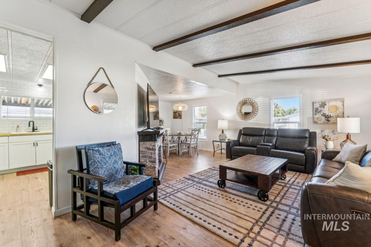 Living area featuring beam ceiling, light wood-style floors, and a textured ceiling