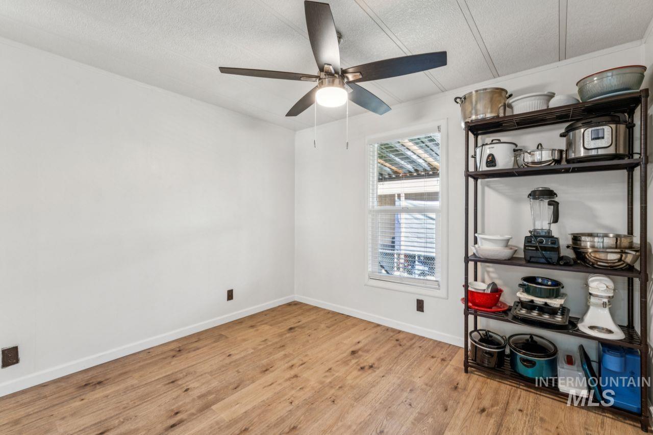 Unfurnished room with light wood-style floors, a textured ceiling, and a ceiling fan