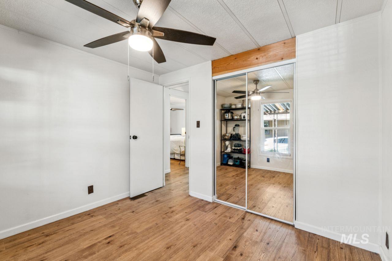 Unfurnished bedroom with wood finished floors, a closet, and ceiling fan